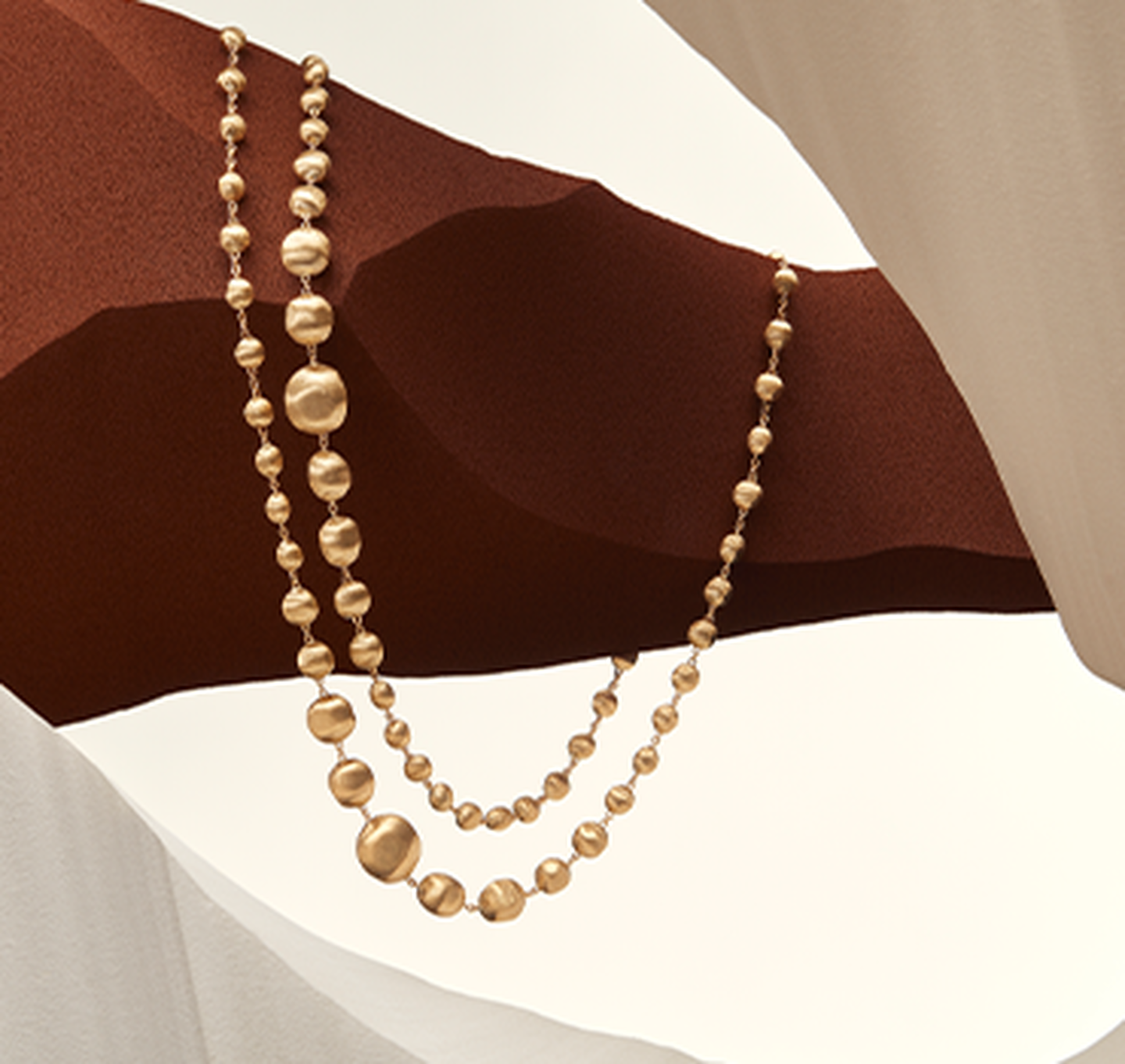 Africa necklaces resting on a sandy background.